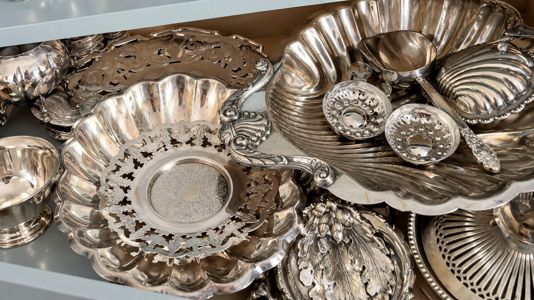 Vintage silver serving pieces arranged in a drawer