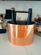 Copper champagne bucket showing the polished exterior and riveted handles