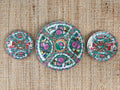 Three vintage Rose Medallion plates arranged as a vertical plate wall trio, one 10 inch and two 6 inch
